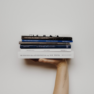 Фрагмент руки, держащей стопку книг