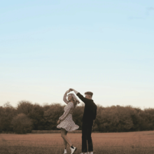 A man and a woman dancing in a field